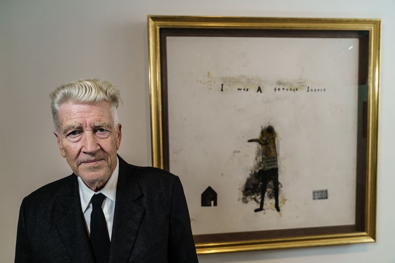 a man named David Lynch standing in front of a painting