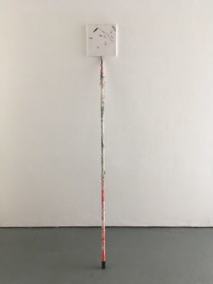 White gallery wall with a small square abstract frame on the wall, at the top of a wrapped post, similar to the size of a broom handle