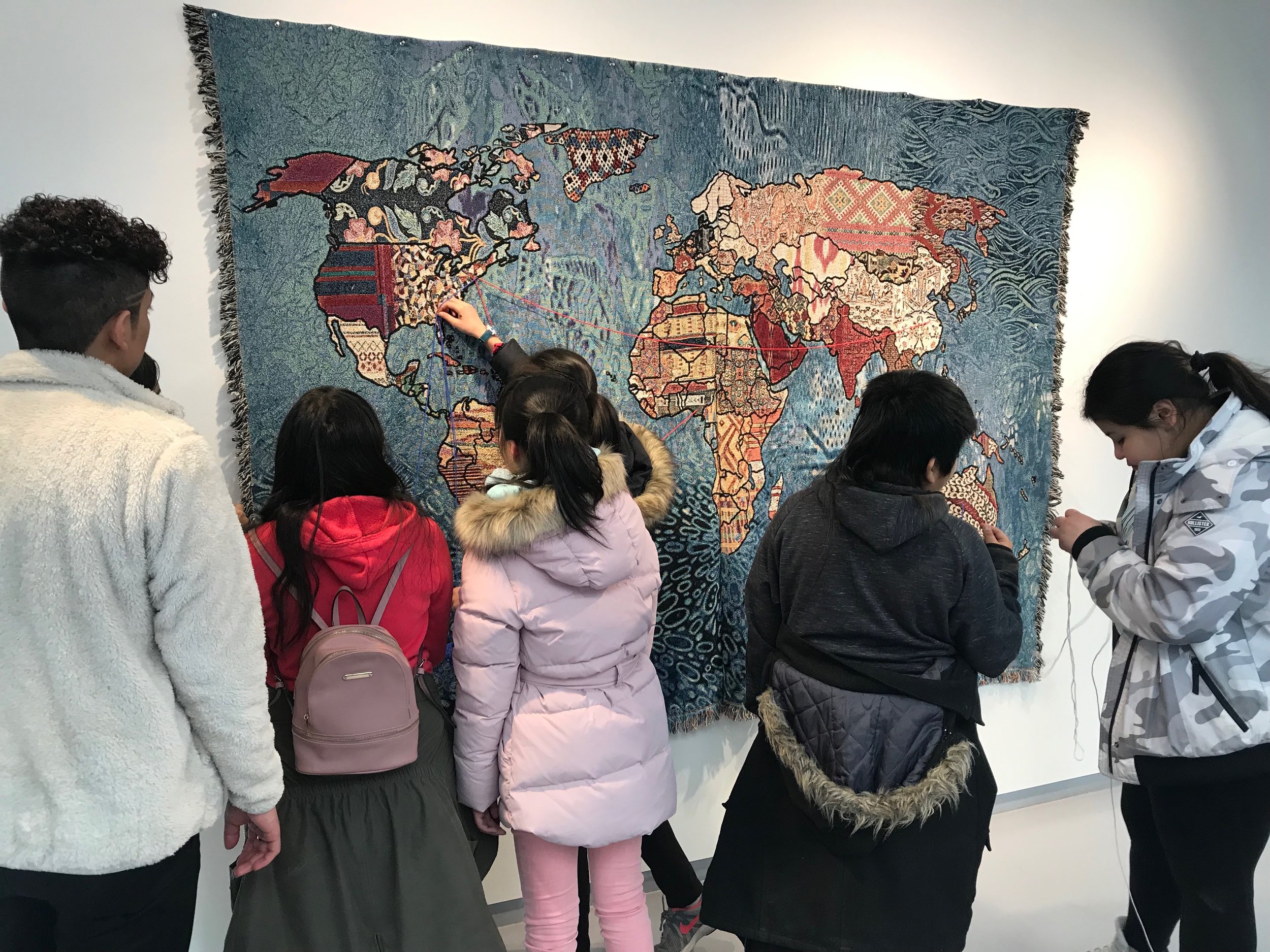 IMG_7107 A family stands in front of a textile map of the world.